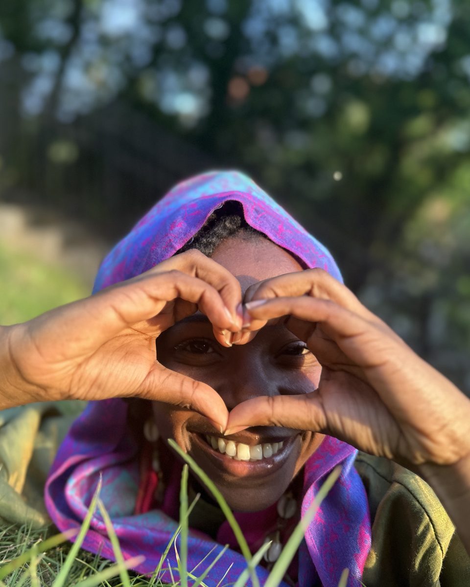 Kait smiling, making a heart with her hands